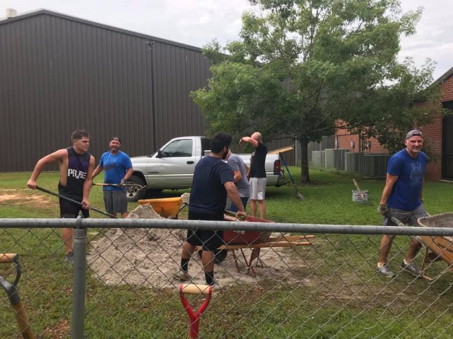 HELPING+HANDS.+Giving+back+to+the+community+that+supports+them%2C+junior+Jace+Halbaedier+shovels+sand+at+Presbyterian+Day+School.+During+the+summer+many+of+the+football+players+volunteered+to+help+members+of+the+community.+%E2%80%9CWe+figured+that+we+should+help+others%2C%E2%80%9D+Halbaedier+said.+%E2%80%9CSo+we+said+why+not%2C+went+a+grabbed+a+wheel+board%2C+a+couple+shovels+and+went+at+it.%E2%80%9D