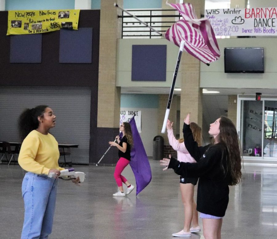 At after school practice, junior Kasey McGrew works on fundamentals with freshman Tory Pierce. The Winter Guard  practices after school and during their 7th period class.