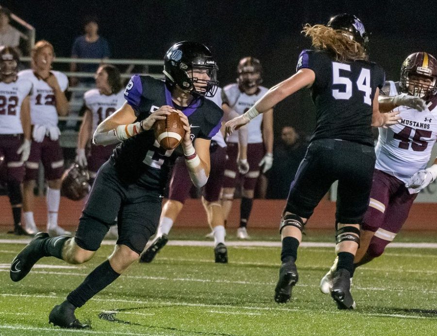 ALL IN. In the game against Magnola West in 2019, senior Steele Bardwell looks to complete a pass while senior Andy Parker makes a block. 