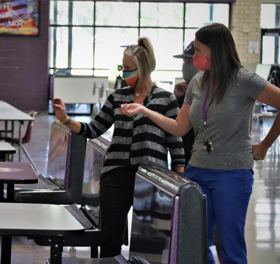 GETTING READY. Wearing colorful mask, members of the schools COVID Task Force, teacher Brandy King and nurse Hailey Dobraski, prepare the cafeteria for lunch when students return. Wearing mask is just one of many safety precautions in place for when students return on Tuesday, 