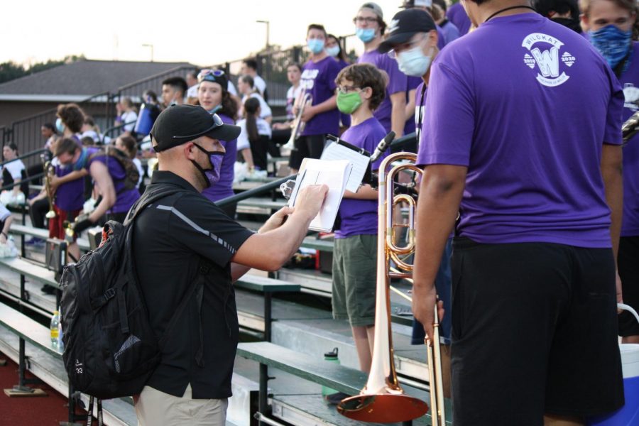 MAKING+ADJUSTMENTS.+Doing+his+best+to+keep+band+members+at+a+safe+distance%2C+assistant+band+director+Joseph+Ditfurth+sets+the+seating+arrangement+at+Friday+nights+scrimmage+against+Cy+Falls.+