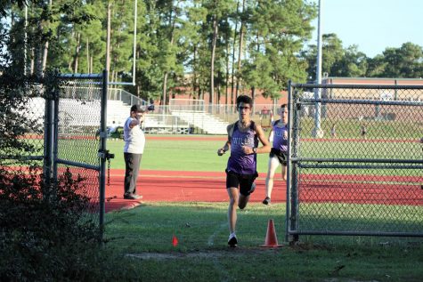 LEADERS OF THE PACK. At the race against Magnolia West, junior Kayman Hatthorn and Braden Kurtz lead the pack of runners from the track to the wooded section of the course. 