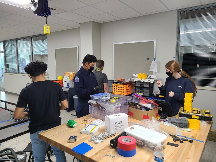 NUTS AND BOLTS. Working on inventory, sophomore Javier Banda, Nathaniel Navarrete, Robert Patteson and junior Kendall Cobb are sorting through all the equipment in the robotics room before they start building their bot.