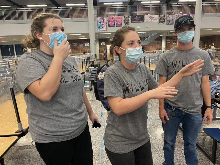 LISTEN TO ME. Passing the day away with games, juniors Katherine Lee, Heather Jackson and Brenan Mansker give clues in a games of Heads Up at regional UIL on Saturday, April 17. 