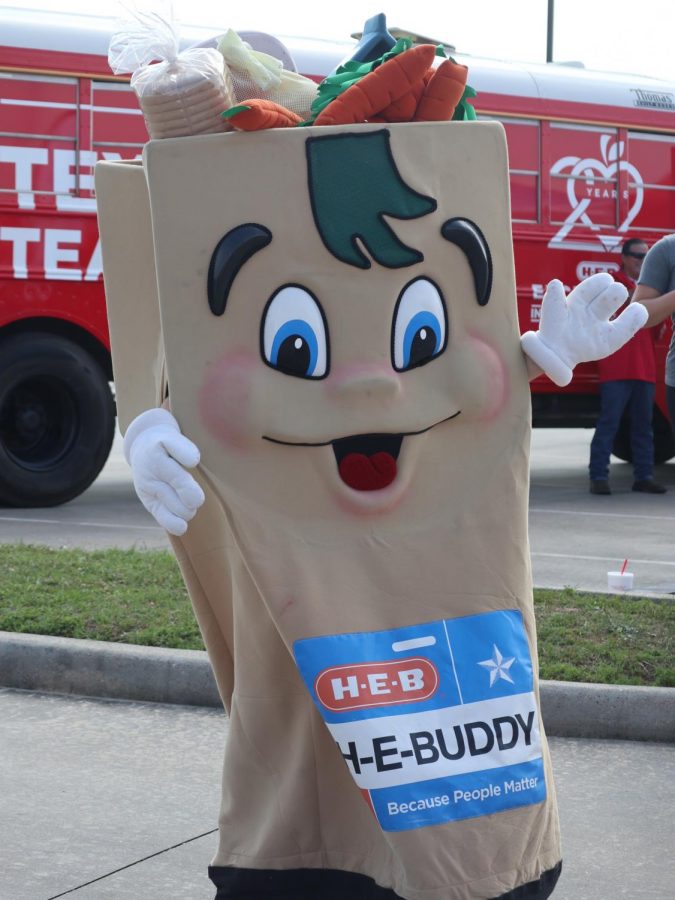 HERE EVERY IS BETTER. HEB Buddy waves at the cars as the teachers and staff drive through the HEB Texas Loves Teachers Tour. 