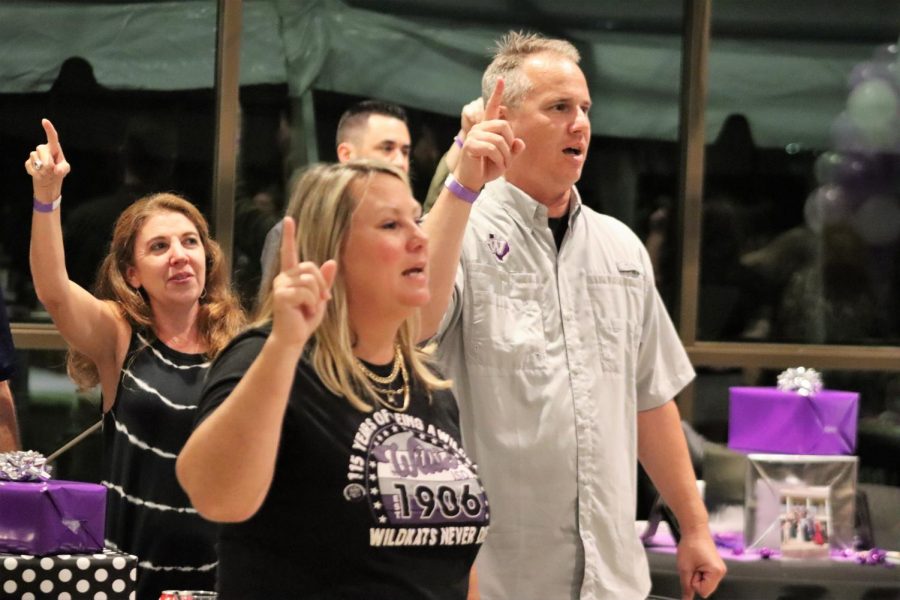 PURPLES FOR VALOR. With their fingers high Nicole Utecht, Kim Eckert and Paul Bischof sing  WHSs school song at the end of the 115th birthday bash.
