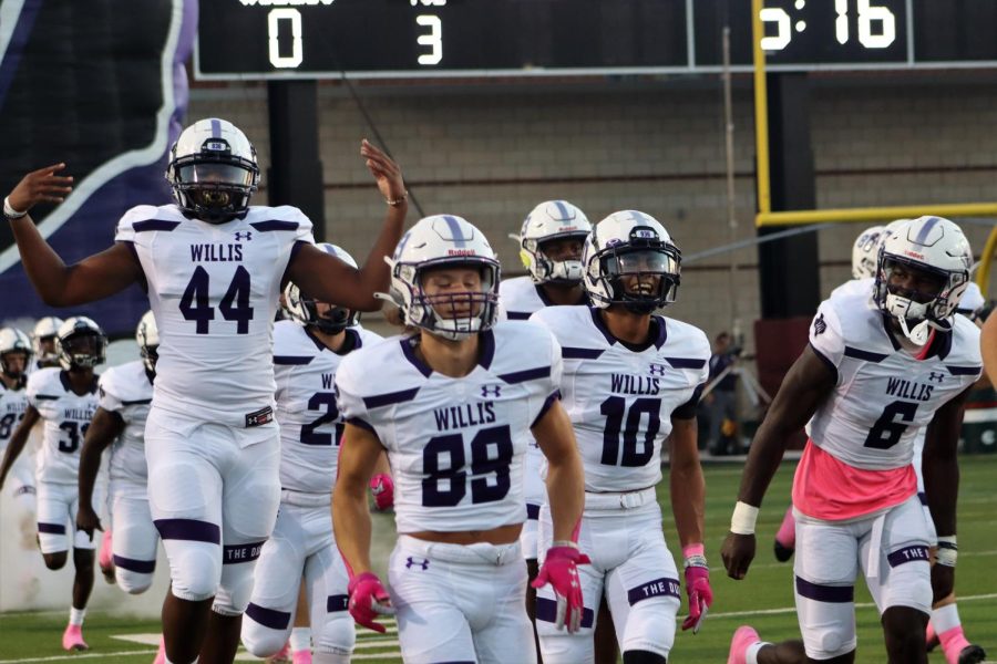 PROUD+AND+PINK.+On+Pink+Out+Night+in+the+game+against+The+Woodlands%2C+seniors+Xzavier+Ross%2C+Tanner+Hayes%2C+Jorge+Garcia+and+Trevor+Jones+run+on+the+field+at+Woodforest+Stadium.+The+game+was+held+on+a+Thursday+because+The+Woodlands+shares+stadiums+with+College+Park%2C+Oak+Ridge%2C+Grand+Oaks%2C+Conroe+and+Caney+Creek+High+Schools.+