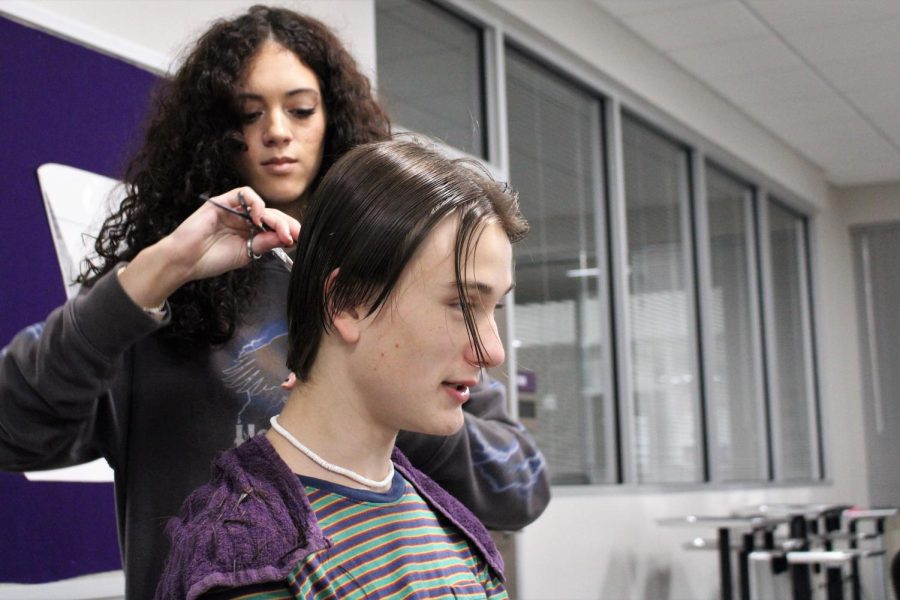SNIP SNIP. Working on accumulating her hours of practice before taking her board exam, senior Gabbie Pena trims sophomore Stone Chapmans hair during class. 