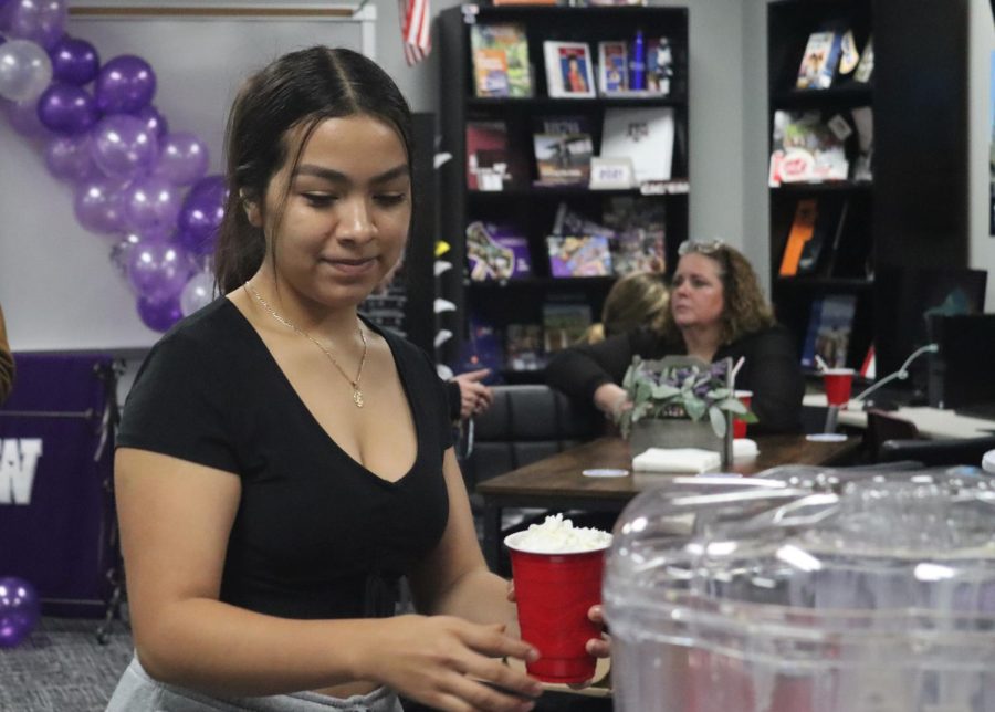 COFFEE CELEBRATION. At the Coffee with Counselors event, senior Maria Flores grabs a straw for her drink. 
