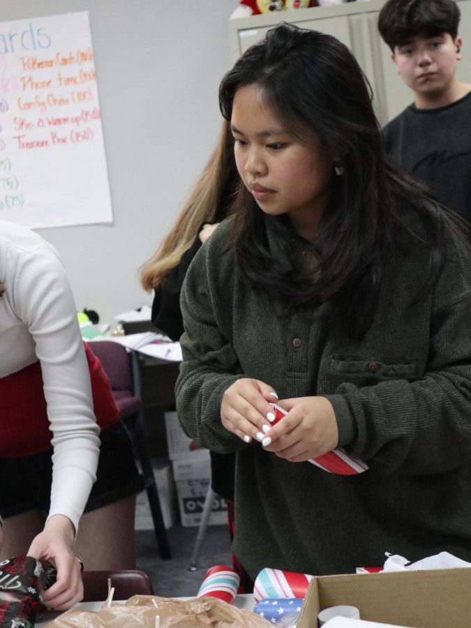 LEADER OF THE PACK. Filling a roll with candy, junior Ivy Nguyen works with the Interact club on their service project. Nguyen is president of the club. 