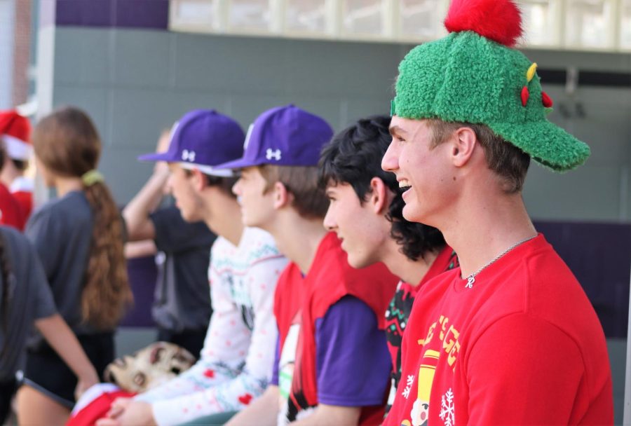 CHRISTMAS CRAZINESSES. Watching his teammates, junior Logan Wilson is amazed by the antics and costumes on the field. 