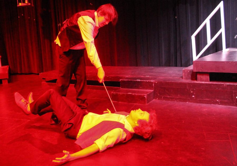 BLOOD FEUD. Red lights flood the stage as Romeo played by junior Brodie McNew stabs Tybalt played by junior Ben Bowles during a school day performance of Romeo and Juliet.