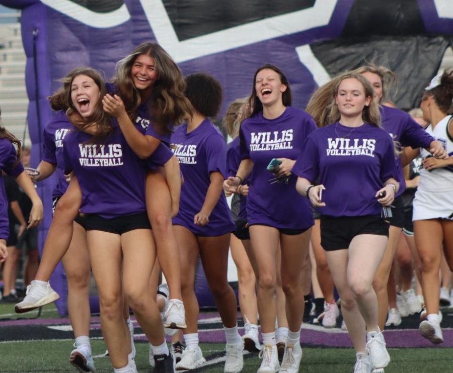 WE+ARE+WILLIS.+At+Meet+the+Kats%2C+senior+Savannah+Paske+hitches+a+ride+on+the+back+of+sophomore+Carly+Paugh+as+the+volleyball+team+is+announced.+The+event+included+all+teams%2C+band%2C+sweethearts%2C+cheer+and+ROTC+in+an+effort+to+build+an+espirit+de+corps+in+the+Wilkdat+community.+A+goal+of+new+principal+Chad+Smith+is+to+increase+school+spirit+at+the+school+and+in+the+community.