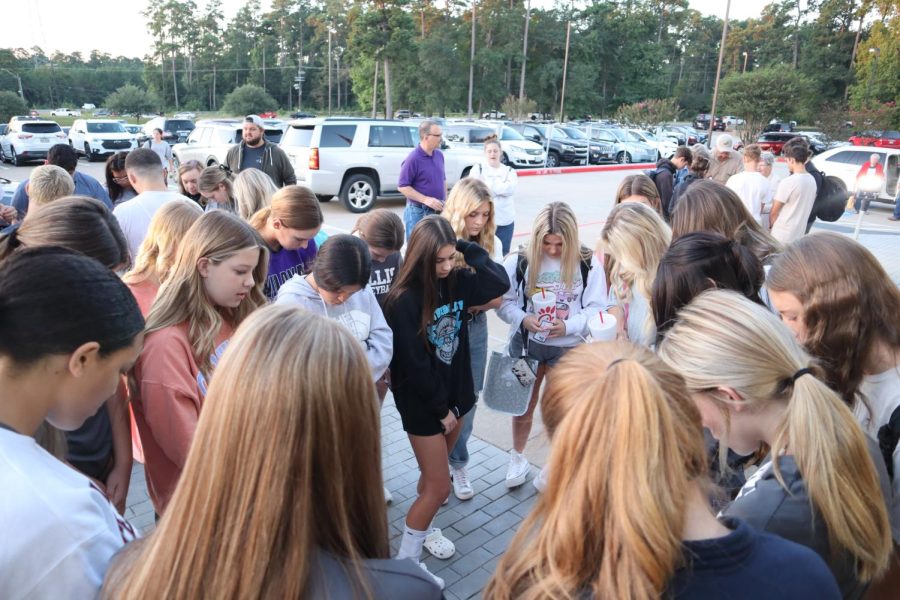 IN HIS NAME. The group of students, parents and community members end See You at the Pole in prayer. 