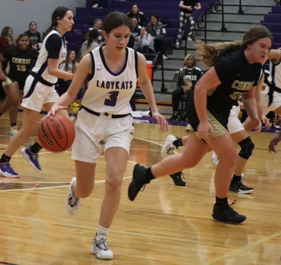 During a game of the 2022 season, junior Kaleigh Kibbey moves the ball down the court.