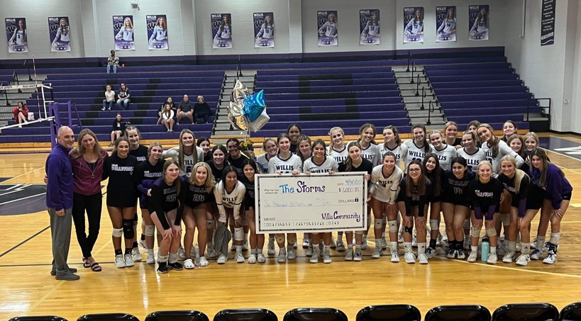 THROUGH THE STORM. Members of the volleyball teams present a check their coach, Megan Storms and her husband Michael Storms. The money aas raising through the month of September for the family.
