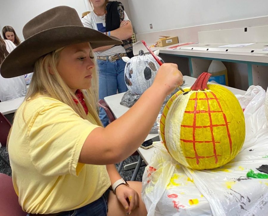 YOU HAVE A FRIEND IN ME. Working on her Woody pumpkin, sophomore Zoey Varner paints during softball bootcamp.