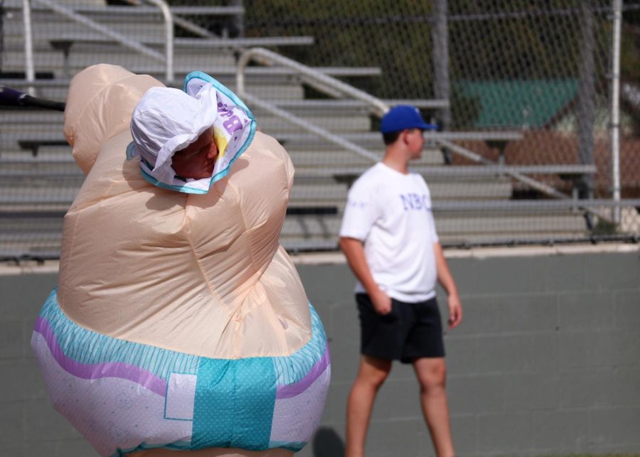 BABY AT BAT. On Halloween, senior Landon Morgan swings at a pitch in his inflatable baby costume. Many of the players popped their blow up costumes with their cleats during the scrimmage. 