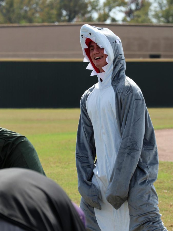JAWSOME FUN. Showing off his shark onesie, senior logan Wilson peps up the players before the game. 