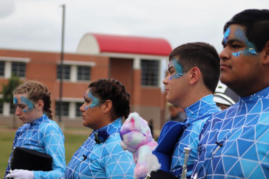 INTO THE BLUE. Masked with blue pain and rhinestones, the drum majors wait to take the field at area.