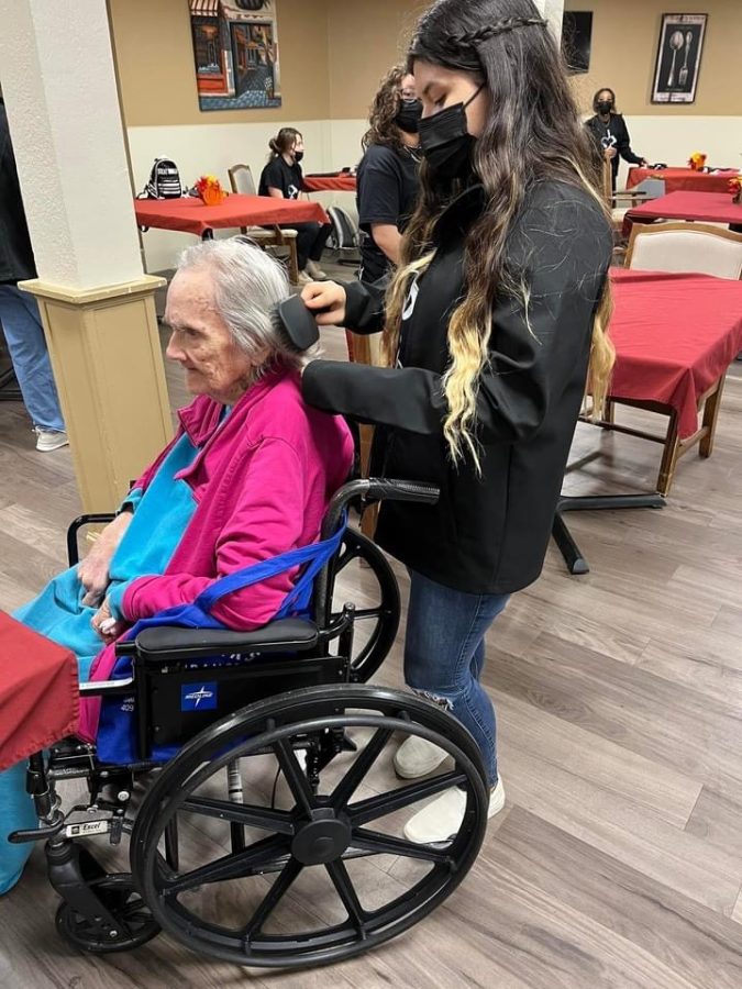 SITTING PRETTY. Working on a residents hair, junior Marlene De Aguila gives back to community by volunteering at the center. 