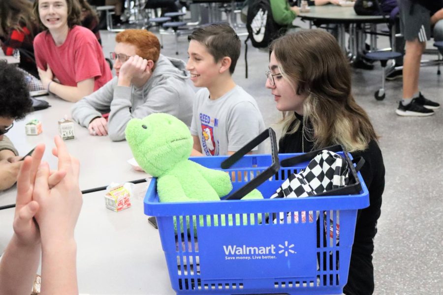 WHAT BACKPACK? Using a Walmart basket to carry her essentials, junior Sypher East eats lunch with her friends on Thursday. The day was designated Anything But a Backpack day in honor of the swim and dive teams district meet.