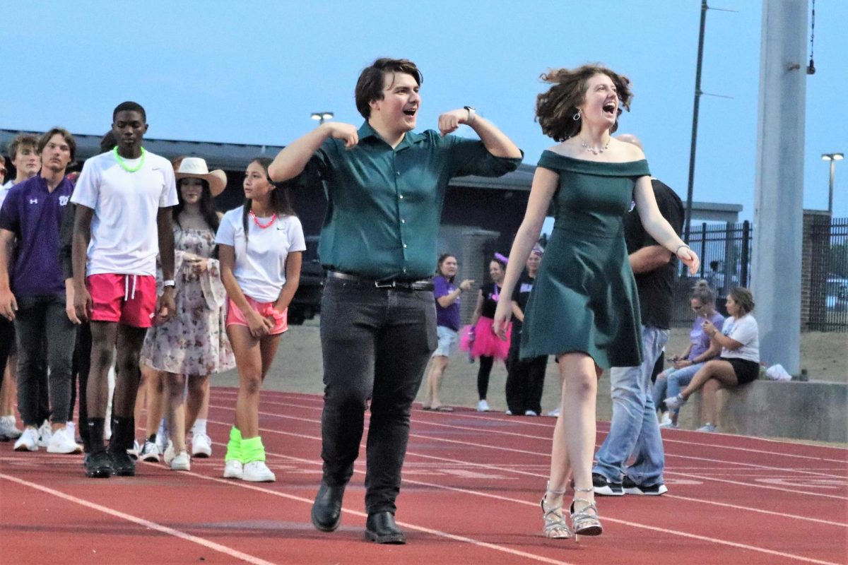 TALENTED DUO. The choir beau and belle, seniors Tripp Brown and Breanna Keelen walk the track during FIre Up the Kats.