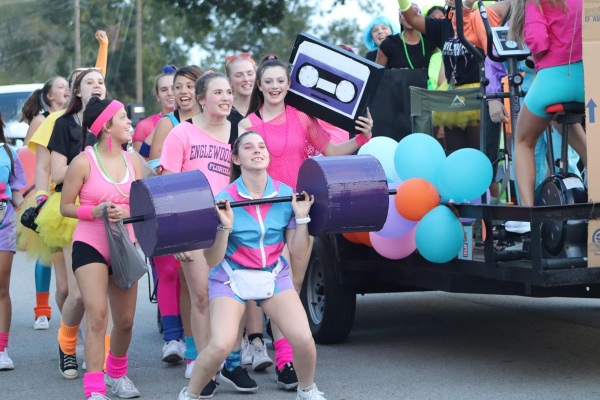 HEAVY LIFTING. The girls basketball team shows they are not afraid of a little hard work with their 80s gym themed float.