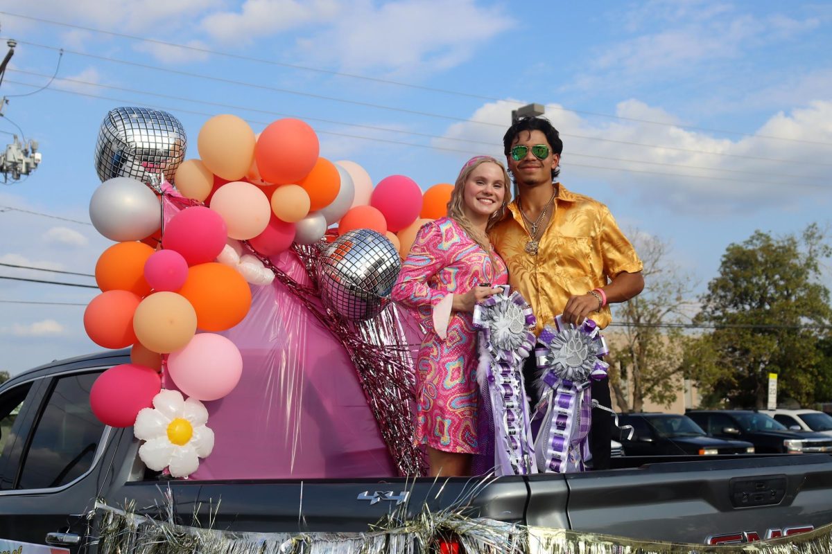 FLOWER CHILDREN. Ready for the parade to start, seniors Grace Wilder and Jaden Mendajavar are proud members of the hoco court. 