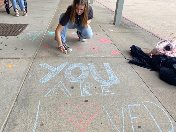 CHALK THE WALK. KJ4H members write kind words on the sidewalks for students to see on their way to class.