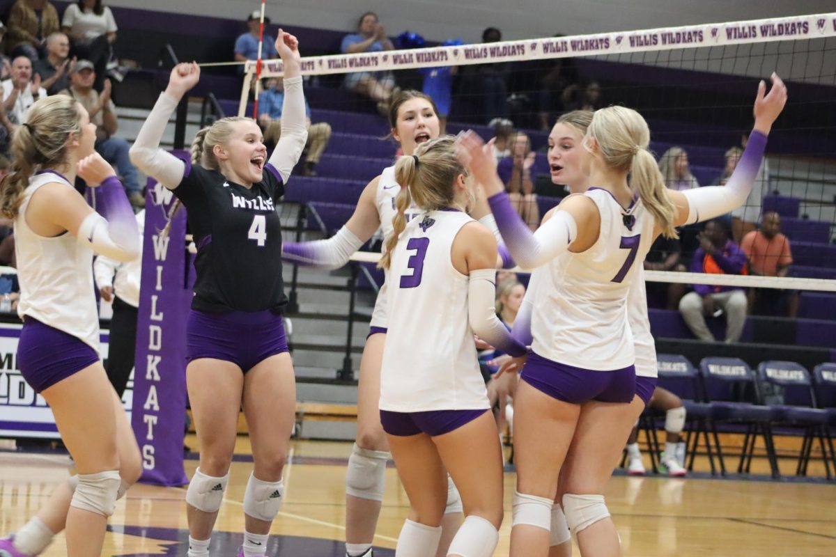 TOGETHER. Celebrating a point against the Eagles, senior Grace Wilder joins seniors Sam Skelton, Sophie Satterwhite and Haley Truett with junior Carly Paugh and sophomore Tori Greeney. 