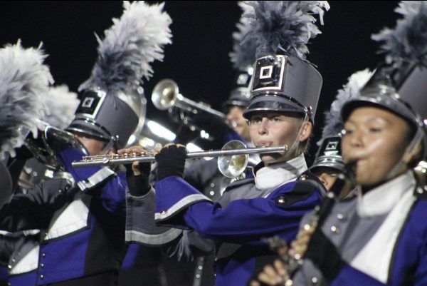 FLUTE ON THE FIELD. Standing with the marching band, senior Hannah Hutchins plays the flute while performing the UIL routine on Friday Night. 