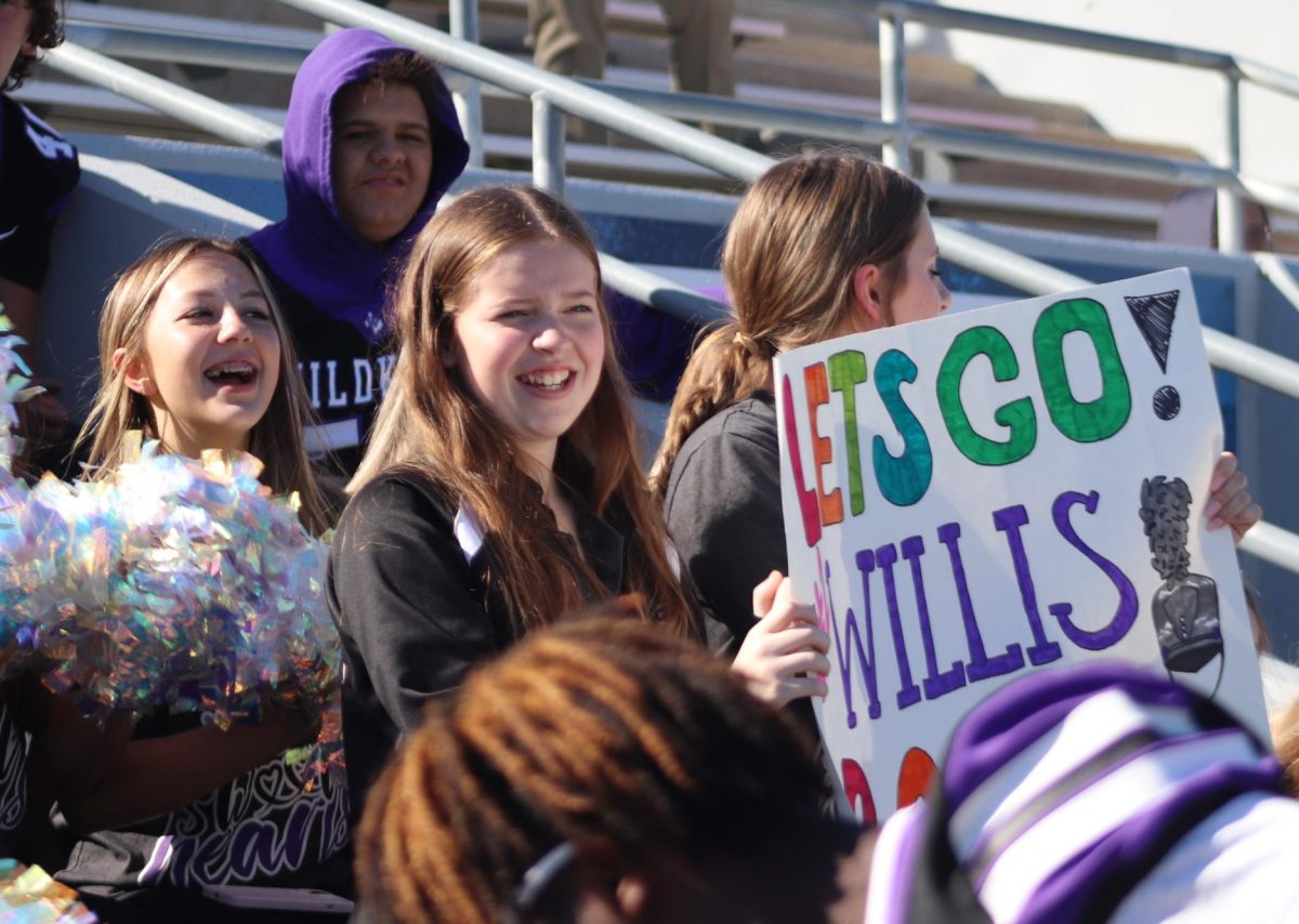 SWEETHEART SUPPORT. With her dance team, freshmen Katie Cruz and Barbara McDonald yells for the band. The dance team and the football team traveled to the contest to support the band. 