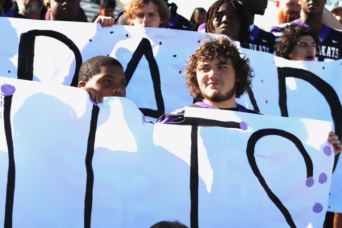 GO BAND. WIth the varsity football team, sophomore Jakayden Thompson and junior Mason Isbell hold a sign of support during the area contest. 