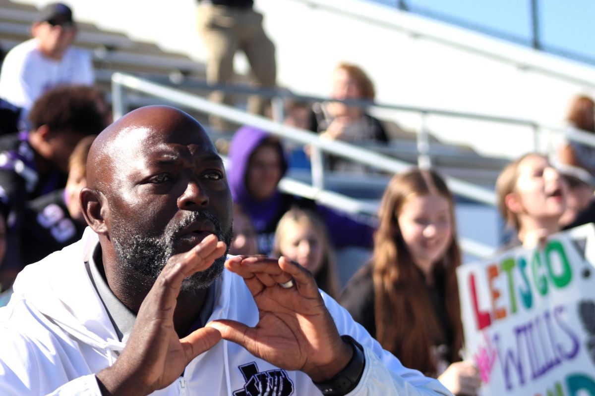 LEAD BY EXAMPLE. Supporting all aspects of Wildkat life, Athletic Director Jason Glenn cheers on the band at area contest at Woodforest Stadium.