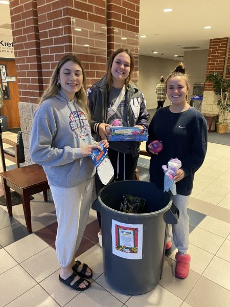 WORKING TOGETHER. Joining other Joined for Hope clubs, members from Kats Joined for Hope, senior Addison Lyons, junior Carli Murray and junior Mallori Mitchell donate toys at the Into the Darkness Walk.