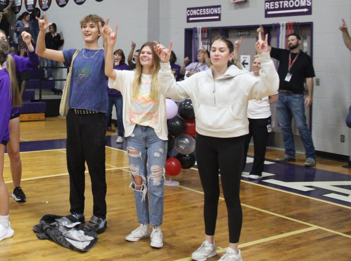 PINKIES LINKED. Student council officers seniors Stone Chapman, Kinley Gibbs and Addison Lyons link pinkies during the school song at the first pep rally of the year. School tradition is that all students link pinkies for the school song.