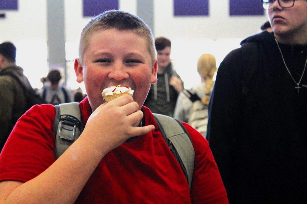 CUPCAKE CRAZY. Enjoying the award after his perfect attendance, freshman Keegan Holden eats his cupcake during the 1000 Cupcake Party on Monday. Students were rewarded for straight As and perfect attendance at the bash featuring 1000 cupcakes. photo by Kyndall Schiffner