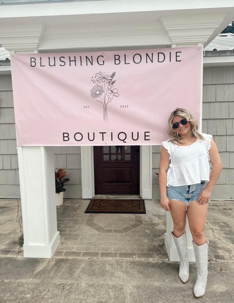 DREAMS COME TRUE.  In front of the store she had hoped for, junior Abigail Alanis celebrates Blushing Blonde Boutique. 