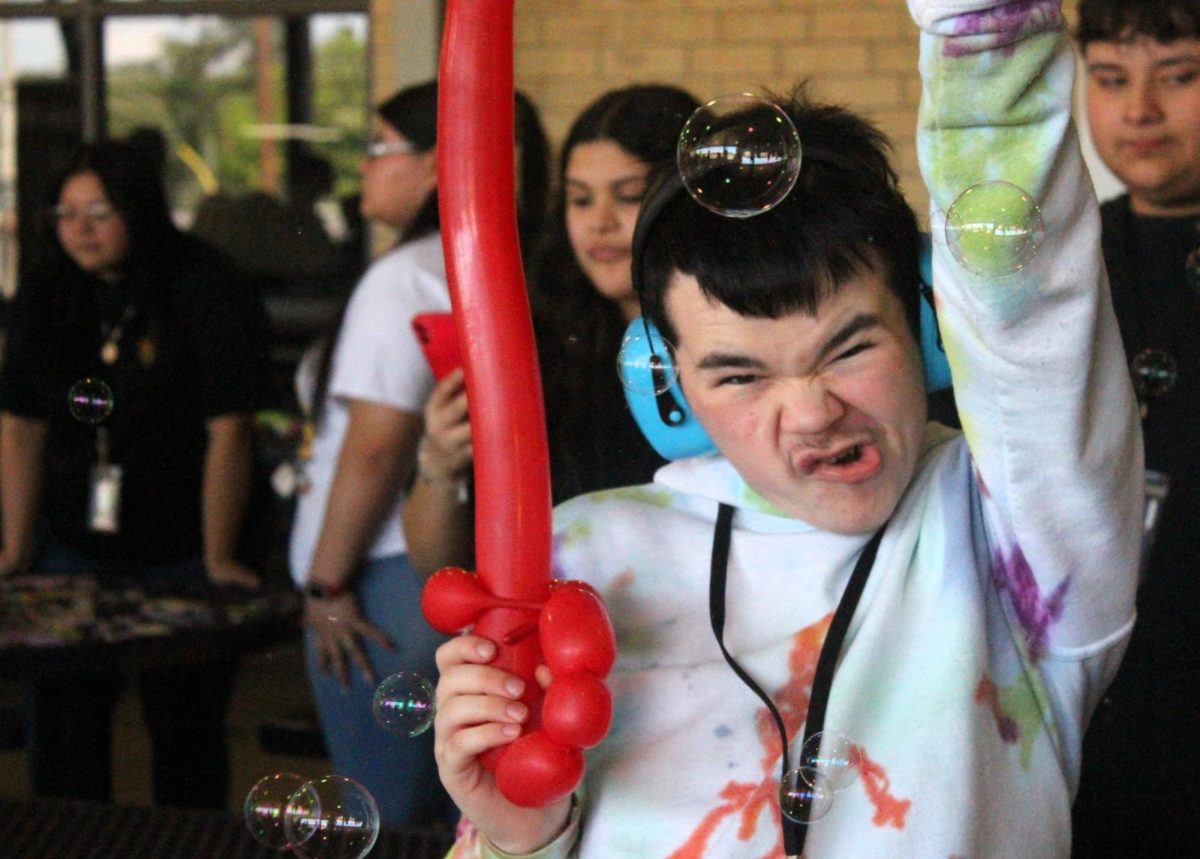 SPRING INTO FUN. Enjoy the fun of the Easter party hosted by Spanish National Honor Society, junior PJ Hahs plays in the bubbles with his balloon sword. photo by Ashley Briones