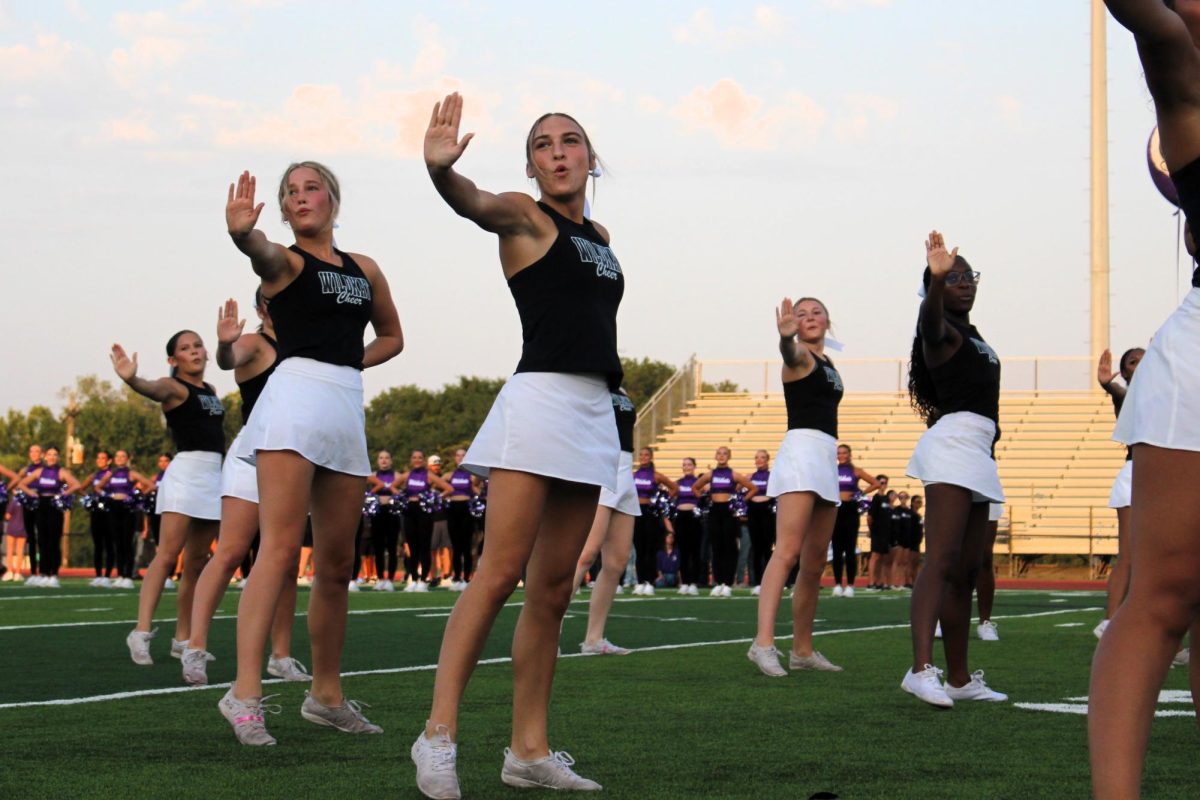 WE ARE WILLIS. Willis varsity cheer shows off their skills during Meet the Kats, senior Triniti McPheron and junior Kyndall Schiffner perform their well prepared dance for the Willis community. “I felt confident enough that I was going to perform and hit well,” McPheron said. “The nerves hit, but when I got in front of the crown, it went away and nothing else mattered.”
