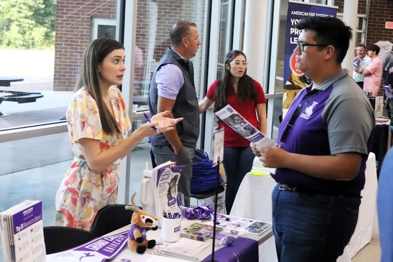 FIND YOUR PURPOSE. Learning more about Grand Canyon University, senior Chris Aleman visits with GCU representative Taylor Barnes at Wildkats are Going Places Event on Monday. The event featured colleges, technical and trade schools and military representatives. photo by Aurora Shannon
