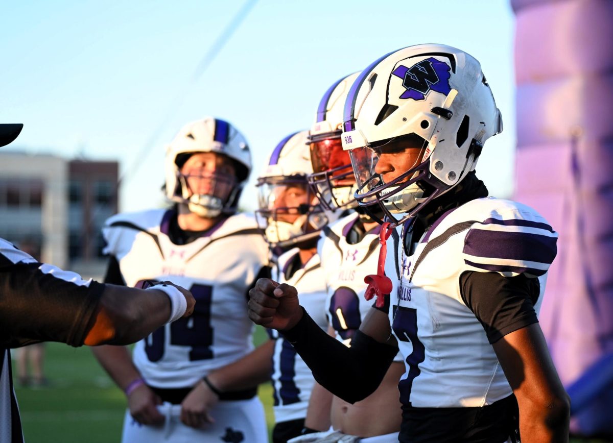 HEADS OR TAILS. At the coin flip, the varsity football captains wait to be told if they are on defense or offense to start the game. The football captains for 24-25 season are seniors Mason Isbell, Jalen Mickens, Luke Reynolds, and junior Jermaine Bishop. 