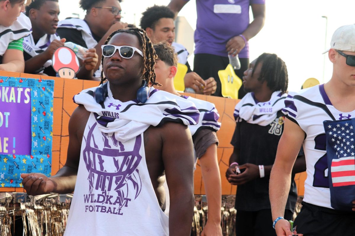 WILDKAT PRIDE. Walking with the varsity football team, senior Terri Lawrence shows off his Wildkat spirit.