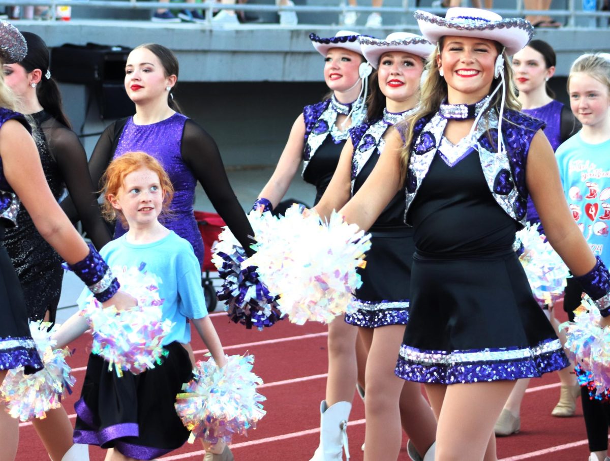 ROLE MODEL. A young girl who participated in the Future Sweethearts clinic looks up at junior Josie Oatman.