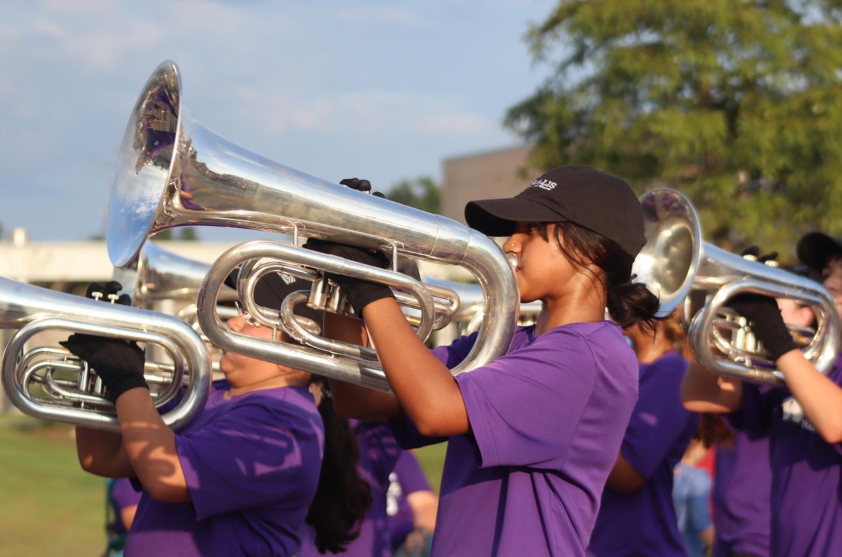 PLAYING HER TUNES. Marching with the band, senior Prima Dabi plays the fight song.