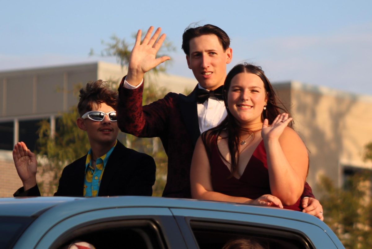 MUSIC TO YOUR EARS. The band representatives, seniors Brianna Cianceruso and Parker Young, wave to the parade crowd. The couple was chosen by the members of band and colorguard for this honor.