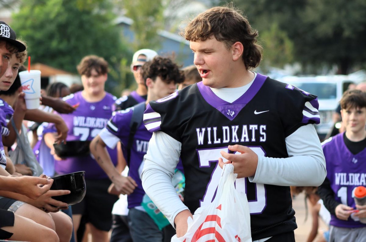 CANDYMAN. Passing out candy to the crowd and his teammates, sophomore Christopher Carmack walks the parade with the JV football float. 
