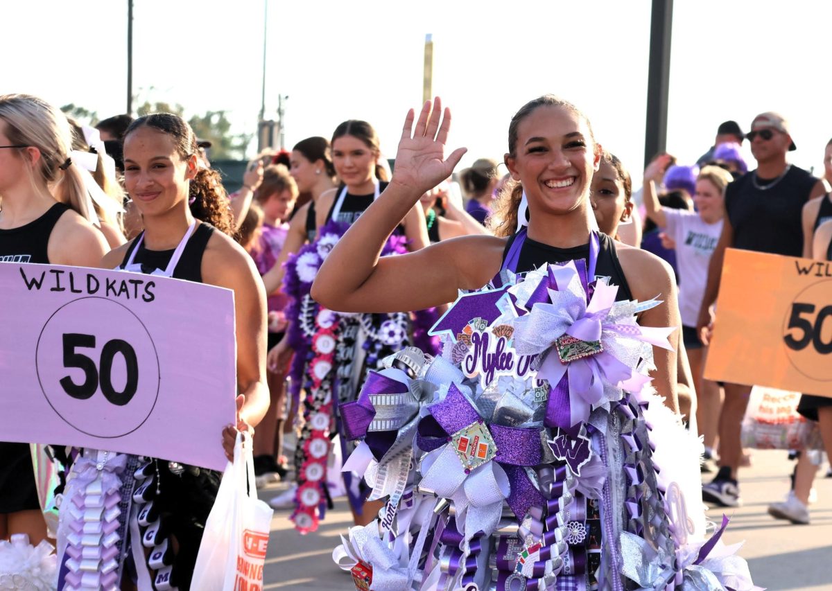 GIANT MUM and GIANT SMILE. With the cheerleaders, senior Mylee Williams waves at the crowd lining the streets of the parade. 