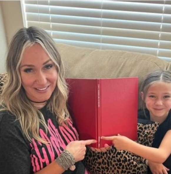 ROLE MODEL. With her daughter, math teacher Jennifer Mitchell shows her name on the spine of her book.  photo courtesy of Jennifer Mitchell